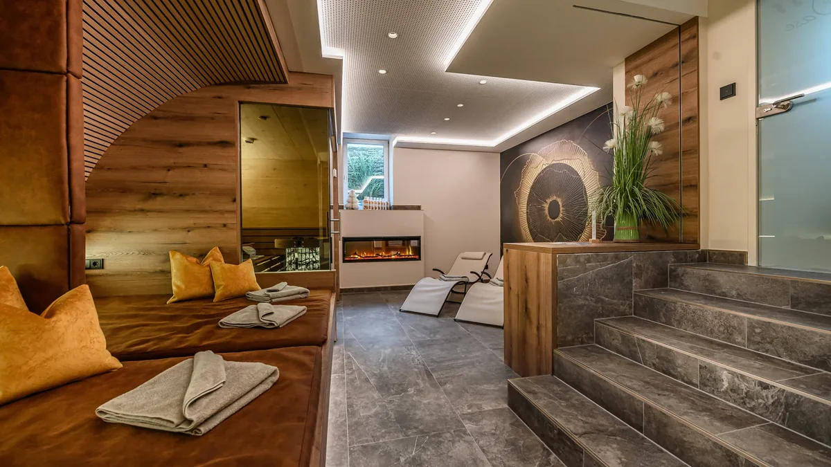 Relaxbereich bei GRUBERS mit mehreren Liegen und Blick durch den Raum zur Wohlfühlsauna