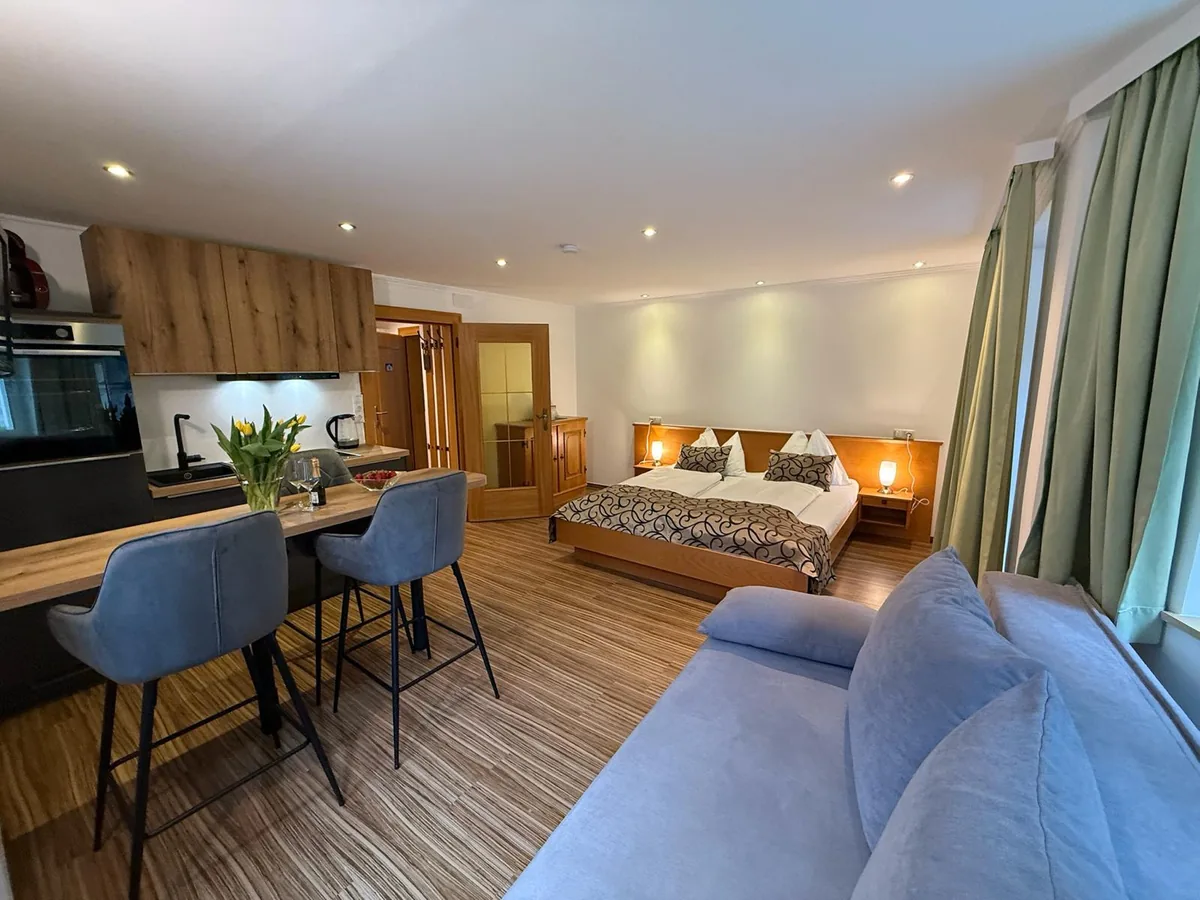 Studio Reedsee in Zimmer 2 mit Doppelbett, Sofa am Fenster, Esstisch und eigener Küchenzeile